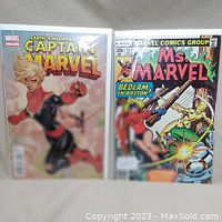 Both comic books displayed side by side showing front covers. Captain Marvel #5 on the left, Ms. Marvel #13 on the right.
