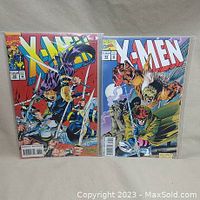 Two Marvel X-Men comic books, issues #32 and #33, bagged and boarded, with colorful covers showing Wolverine and Sabretooth.