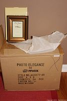 Photo showing a single gold picture frame next to its original box labeled Photo Elegance by M Max, size 4x6, style AG3077-46, made in China.
