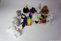 Lot of 12 vintage Ty Beanie Babies stuffed toys arranged in a group, showing various animals such as unicorns, leopard, eagle, monkey, parrot, zebra, elephant, and others, all with tags.