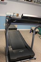 Front-angle view showing running deck, base, frame and support arms.