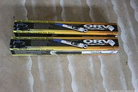 Two boxes of Rugged Ridge ORV Series nitrogen charged gas shocks, laying on carpet floor, with yellow and black packaging and Jeep Wrangler image.