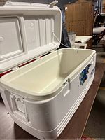 Opened white Igloo cooler showing exterior and lid with logo, latches on sides