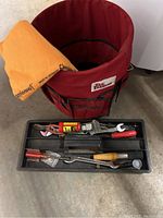 Photo showing red Tool Keeper bucket, tray with assorted hand tools, and orange ShamWow towel draped over bucket edge