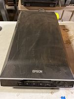 Closed black Epson Perfection V550 Photo Scanner with Epson logo and control buttons visible on the front.