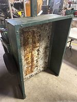 Full view of the metal trailer showing rusted interior base and rectangular metal frame.