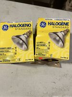 Photo showing two GE Halogen Standard PAR38 light bulbs in their original yellow boxes with product details and specifications.