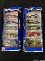 Two unopened Hot Wheels 5-car gift packs side by side showing all cars inside sealed blister packaging.