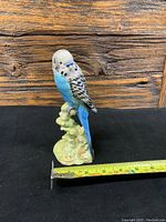 Photo of ceramic Budgie figurine with tape measure showing height of approximately 8 inches.