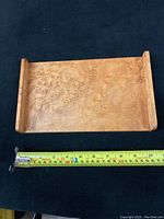 Top-down view of the Bird's Eye Maple tray showing the distinctive grain and raised ends with measuring tape for size reference.