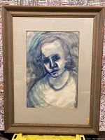 Framed watercolour portrait showing a woman in blue and grey tones, signed Mary McLean.