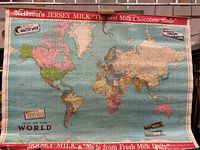 Full view of the vintage world map with Nelson's Jersey Milk advertising and map details.