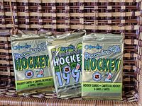 Three sealed 1992 O-Pee-Chee Premier Hockey card packs, each containing 8 cards, shown on a woven background.