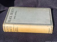 Cover of Antique Black Beauty book by Anna Sewell, light blueish-grey hardcover with text in black.