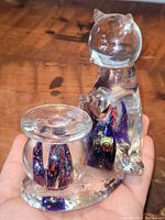 Front side showing clear glass cat figurine sitting next to a round fish bowl with colorful detail inside, used as a candle holder.