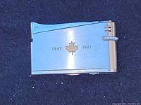 Front view of vintage stainless steel lighter with maple leaf and dates 1867-1967.