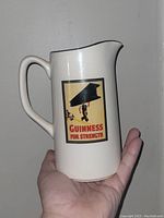 Front side of the ceramic pitcher jug with Guinness For Strength vintage graphic.