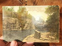 Front side of postcard showing color view of Half Moon Bay, 1000 Islands with natural stone formations and water