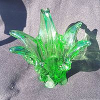 Top view of green hand blown glass basket vase showing multiple curved points and translucent textured glass with bubbles