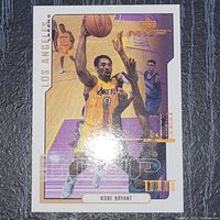 Photo showing the front of the Kobe Bryant Upper Deck basketball card with player in action and Los Angeles Lakers theme.