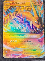 Close-up of the front of the Mega M Charizard EX holographic card showing artwork, holographic foil, character, and text details.