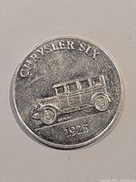 Obverse side of coin showing Chrysler Six 1925 embossed car illustration and text