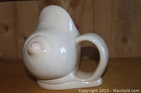 Front angle of the ceramic boob-shaped mug showing the nipple detail and handle.