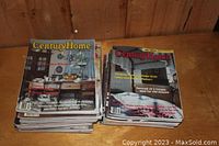 Two stacks of Century Home magazines on a wooden surface showing various issues with old home renovation and decorating covers.
