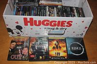 Photo showing a cardboard box with DVDs including Out of Time, Man on Fire, Stealth, Rings on display
