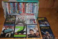 Photo showing a collection of stacked DVDs including Tommy Boy, Zoolander, Dumb and Dumber, Pirates of the Caribbean, and other comedy titles.