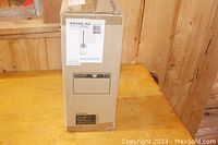 Photo of the unopened Kichler light fixture box on wooden table