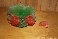 Front side of vintage thick plastic fish decorated bowl with separate small fish figurine placed next to it.