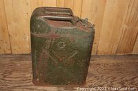 Full side view of the vintage green metal fuel can showing rust and the 'X' reinforcing pattern.