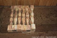 Top-down view of a stack of six wooden carved posts showing the shape and wood grain