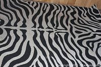 Close-up photo showing the zebra stripe pattern and texture of the rug, highlighting the black and white colors and the pattern detail.