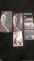 Photo of complete Bruce Springsteen box set with 3 discs, concept book and paperback fact book laid out on black carpet.