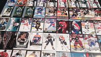 Photo of a collection of hockey cards laid out in rows showing various players and card types