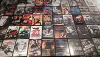 Overview photo showing 65 DVD movie cases arranged side by side on a surface revealing title covers and artwork.