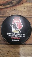 Top view of the official 2009 IIHF World Junior Championship hockey puck showing the event logo and text.