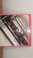 Front cover of The Beatles 1962-1966 double album featuring the iconic image of the band leaning over a railing, bordered in red with some noticeable wear on edges and corners.