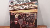 Front side of The Beatles Reel Music vinyl album cover showing the band and marquee with song titles.