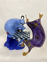 Front view of Genie leaning over the floating chessboard carpet