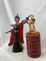 Front view of Jafar figurine and snake hourglass well pieces on white backdrop