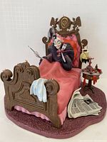 Front view of Cruella de Vil figurine on bed