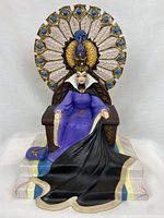Front view of the resin figurine showing the Evil Queen seated on her throne with peacock motif.