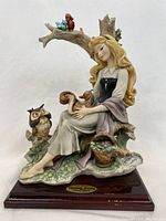 Front view of the multi-color porcelain Sleeping Beauty figurine on wood-tone base