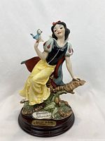 Front, side view of figurine on wooden base with engraved nameplate