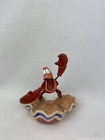 Front view of Sebastian the crab figurine on clam shell base