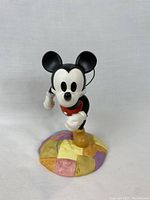 Front view of Mickey Mouse sculpture on colorful patchwork globe base.