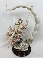 Front view of the Summertime porcelain figurine on wooden base against white background